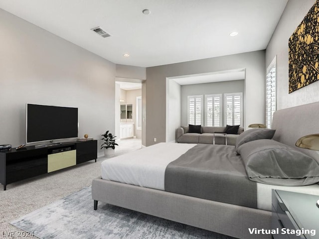 bedroom featuring light colored carpet and ensuite bath