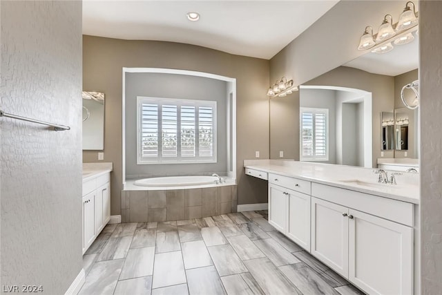 bathroom with tiled bath and vanity