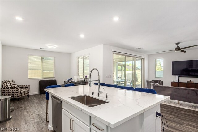 kitchen with sink, white cabinetry, a center island with sink, and a breakfast bar area