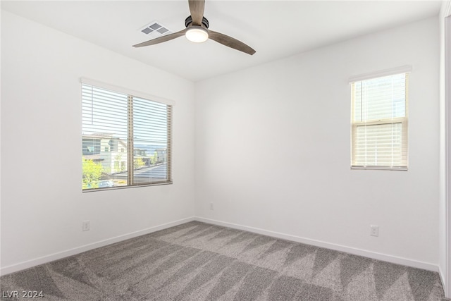 carpeted empty room featuring ceiling fan and a healthy amount of sunlight