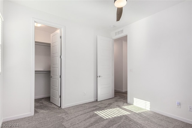 unfurnished bedroom with light carpet, a closet, and ceiling fan