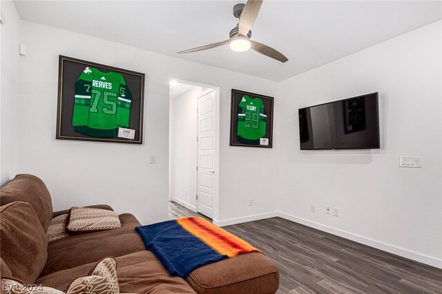 living room featuring ceiling fan and dark hardwood / wood-style floors