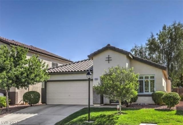 mediterranean / spanish-style home featuring a front yard and a garage