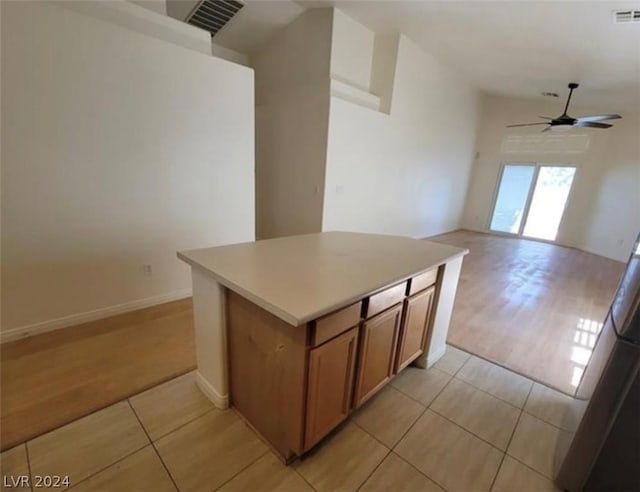 kitchen with ceiling fan, light tile patterned floors, and a center island