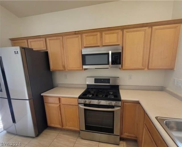 kitchen featuring light tile patterned floors, sink, and stainless steel appliances