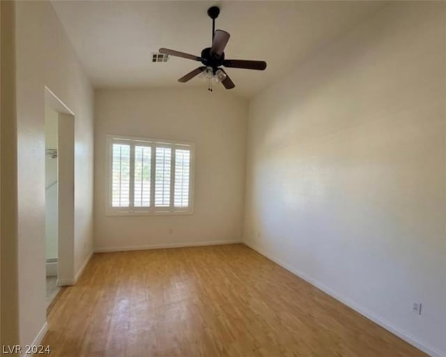 spare room with ceiling fan, light wood-type flooring, and vaulted ceiling