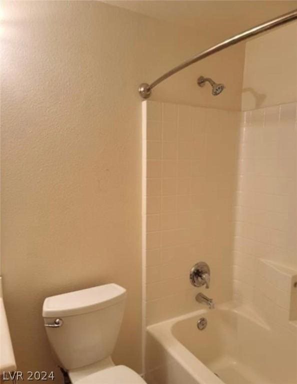 bathroom featuring toilet and tiled shower / bath