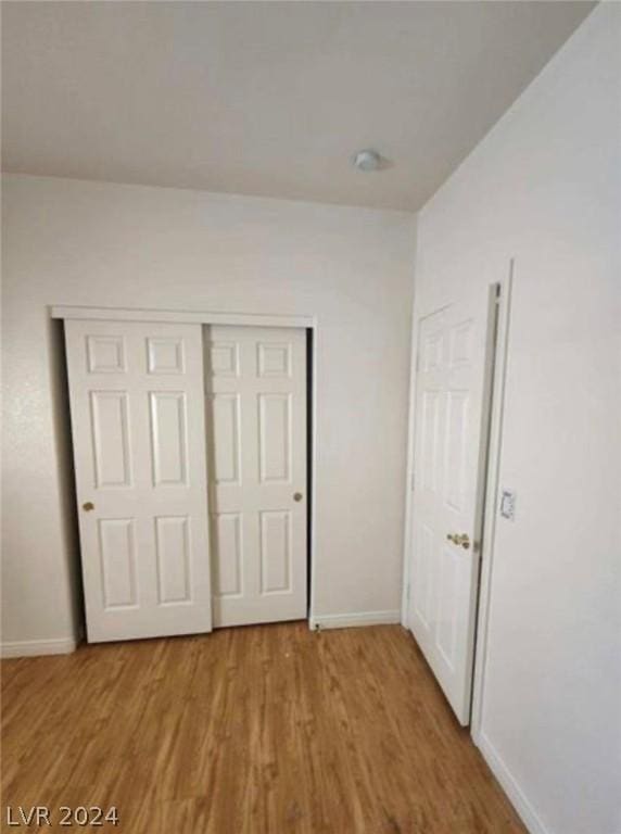 unfurnished bedroom featuring a closet and light hardwood / wood-style floors