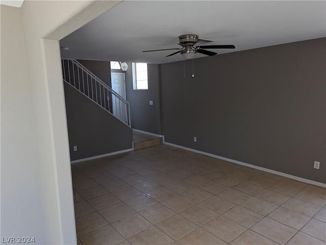 tiled spare room featuring ceiling fan