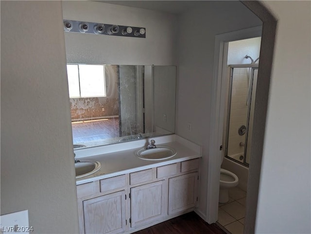 full bathroom featuring toilet, vanity, and combined bath / shower with glass door