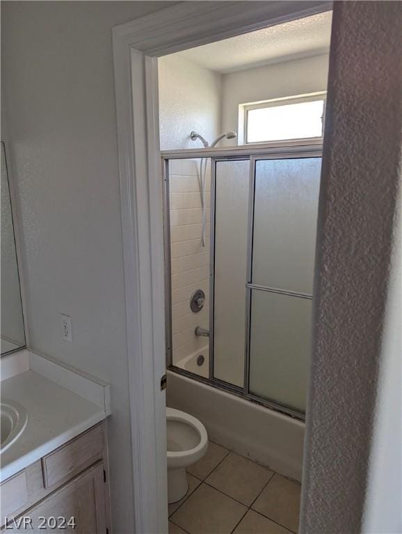 full bathroom featuring vanity, toilet, tile patterned flooring, and combined bath / shower with glass door