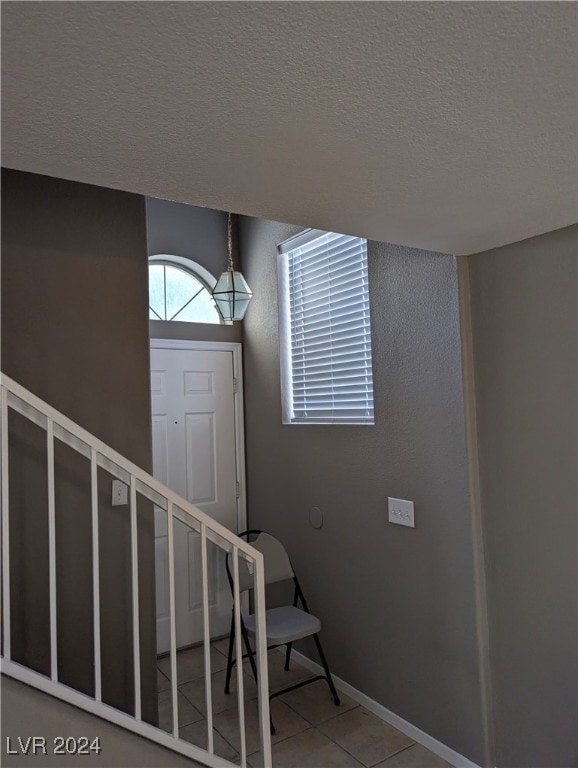 entrance foyer featuring tile patterned flooring and a textured ceiling