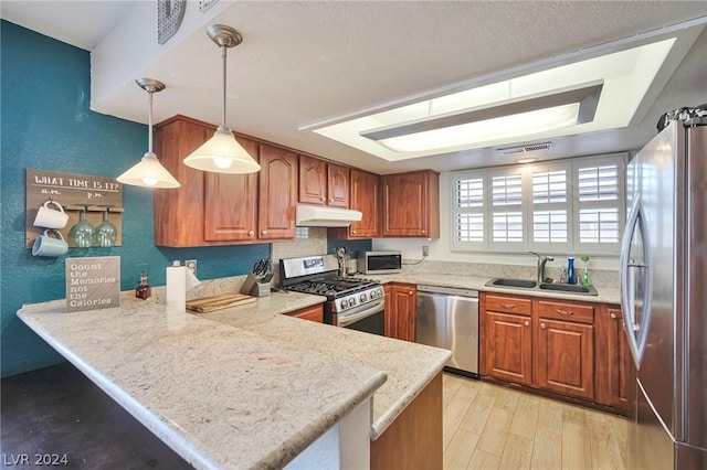 kitchen with kitchen peninsula, decorative light fixtures, stainless steel appliances, and sink