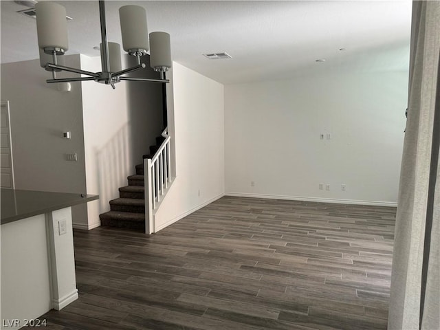 basement with a notable chandelier and dark wood-type flooring