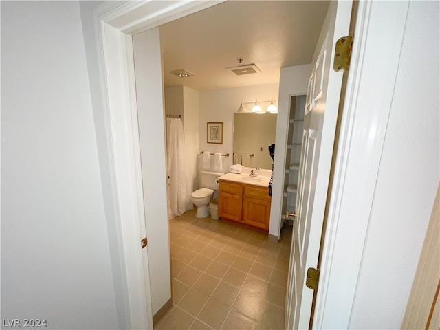 bathroom featuring tile patterned floors, vanity, and toilet