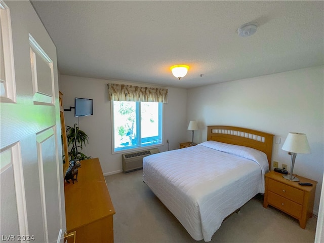 bedroom with light carpet, a textured ceiling, and a wall mounted AC