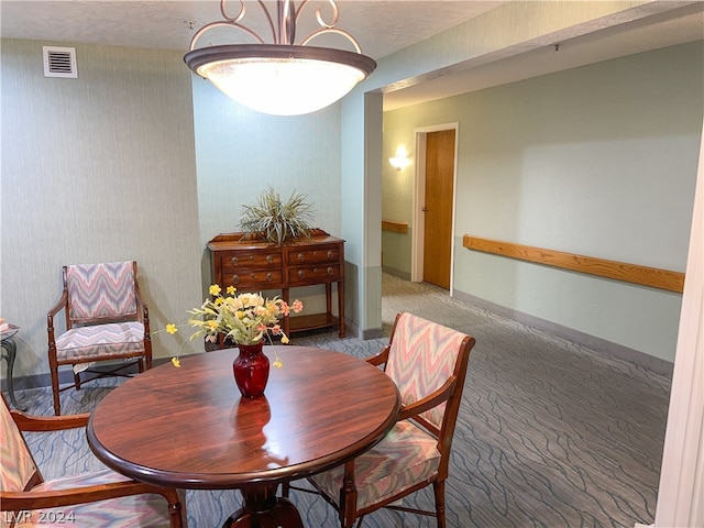 carpeted dining area featuring a textured ceiling