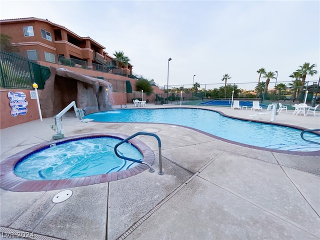 view of swimming pool featuring a community hot tub and a patio