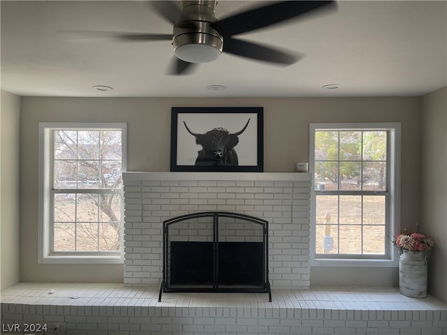 unfurnished living room with a fireplace, ceiling fan, and a healthy amount of sunlight