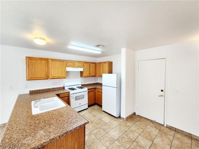 kitchen featuring kitchen peninsula, a textured ceiling, white appliances, sink, and light tile patterned flooring