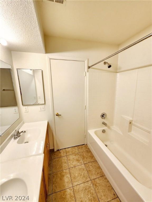 bathroom with tile patterned floors, vanity, and tiled shower / bath combo