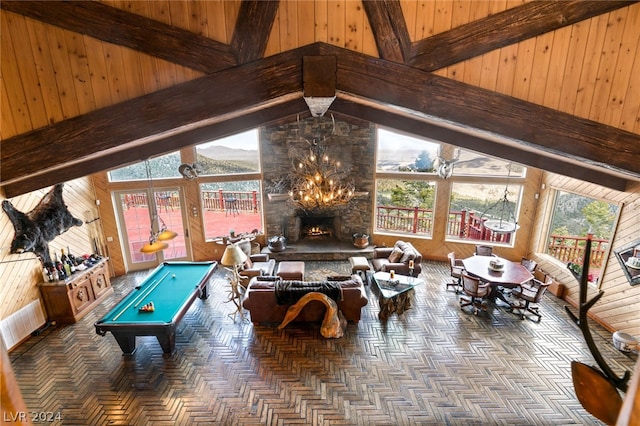 recreation room with high vaulted ceiling, a healthy amount of sunlight, wood walls, and pool table