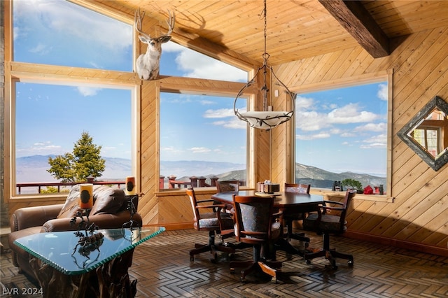 dining room with wood ceiling, high vaulted ceiling, wood walls, and a mountain view