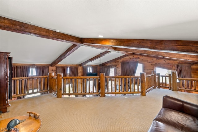 carpeted living room featuring wooden walls and lofted ceiling with beams