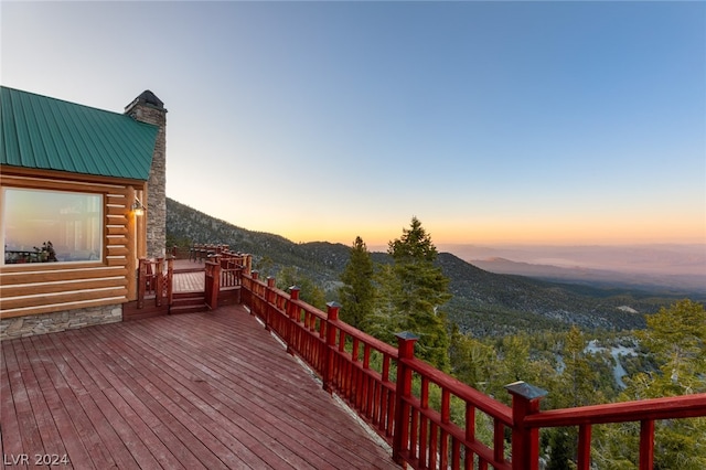 deck at dusk featuring a mountain view