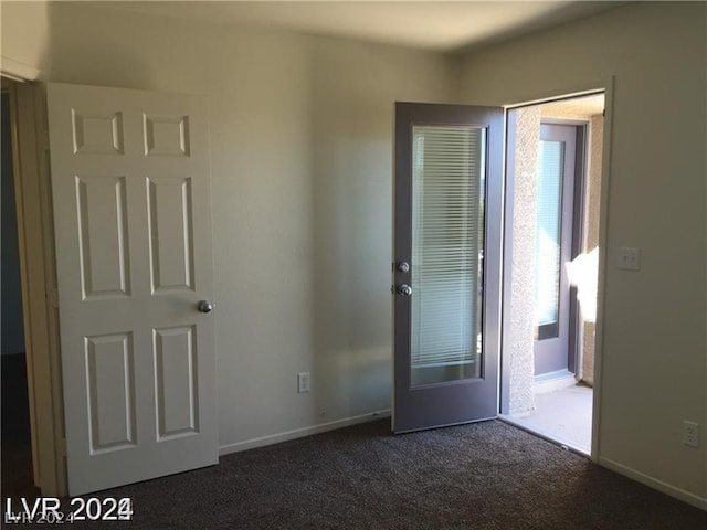 unfurnished room with dark carpet