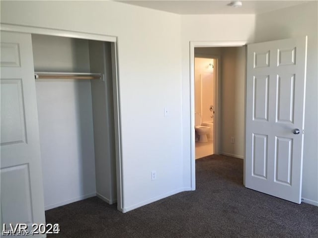 unfurnished bedroom featuring dark carpet and a closet