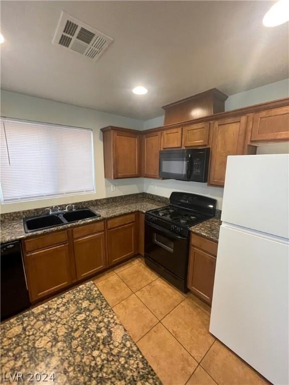 kitchen featuring black appliances, light tile patterned flooring, and sink