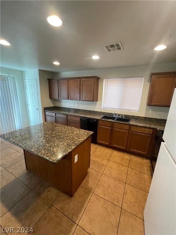 kitchen with dishwasher, a kitchen breakfast bar, sink, light tile patterned floors, and a kitchen island