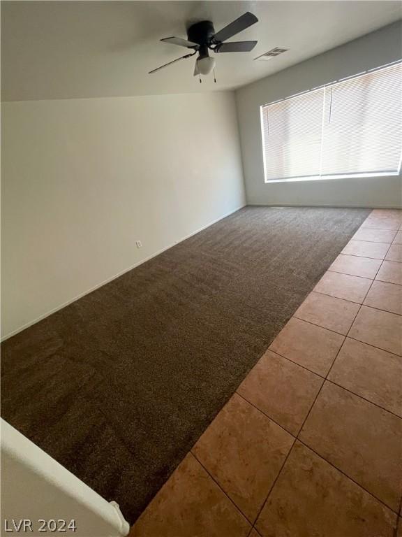 empty room featuring tile patterned flooring and ceiling fan