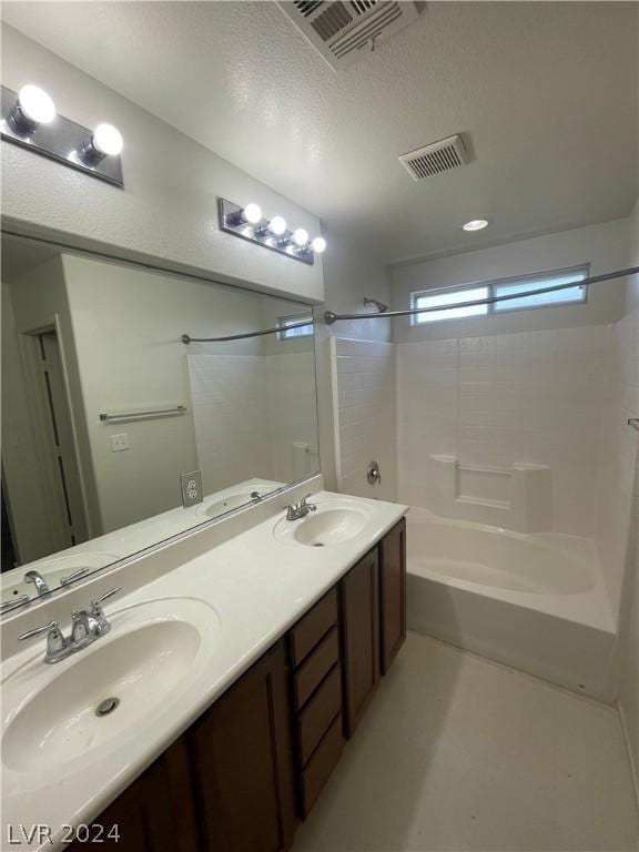 bathroom featuring vanity, shower / tub combination, and a textured ceiling