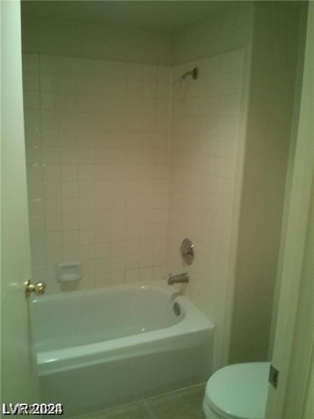 bathroom with tiled shower / bath and toilet