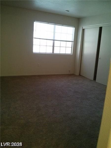 spare room featuring dark carpet