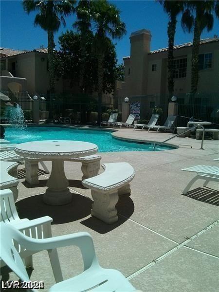 view of swimming pool featuring pool water feature and a patio area