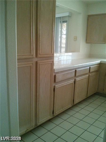 kitchen featuring tile countertops and light tile flooring