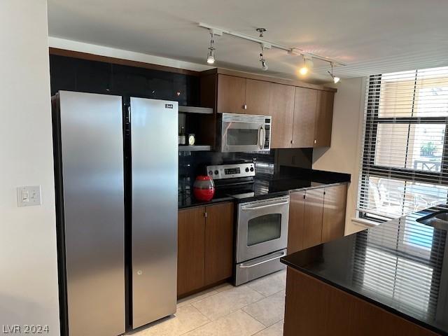 29 Montelago Blvd Unit 201, Henderson, NV 89011 - kitchen featuring rail lighting, light tile patterned floors, and stainless steel appliances