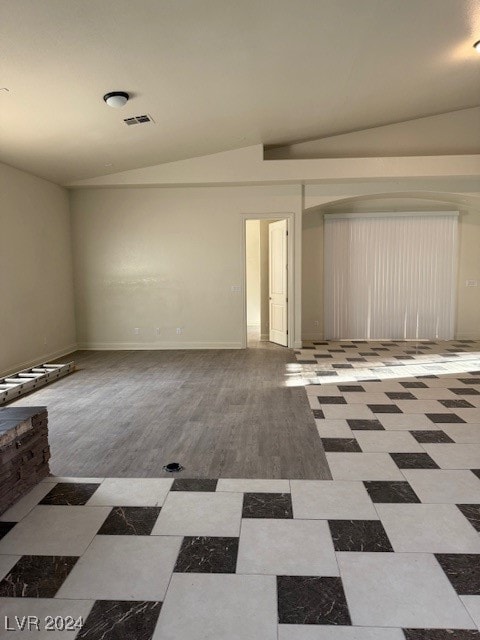 empty room with lofted ceiling and light hardwood / wood-style floors