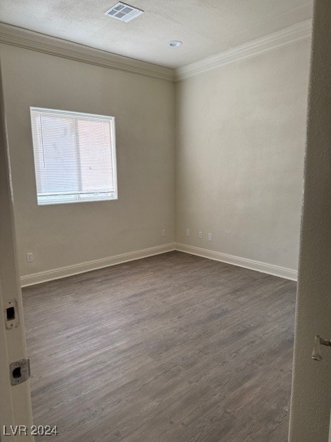 unfurnished room featuring ornamental molding and dark hardwood / wood-style flooring