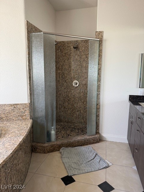 bathroom featuring a tile shower, tile patterned floors, and vanity