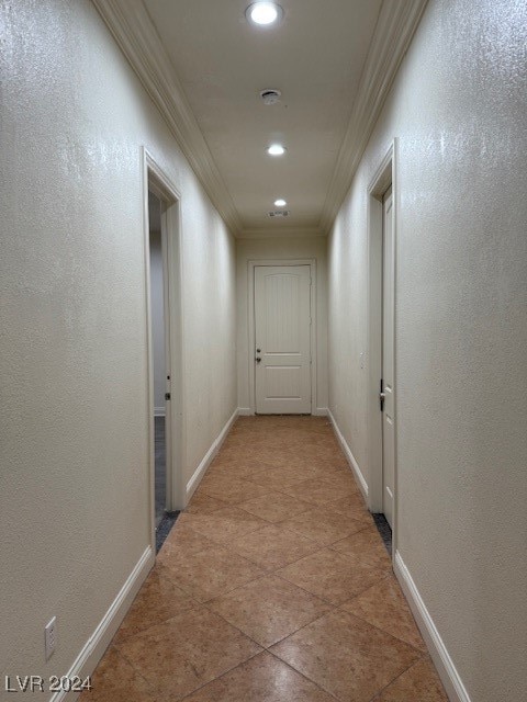 corridor featuring ornamental molding and tile patterned flooring