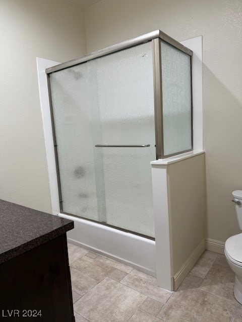 full bathroom with bath / shower combo with glass door, vanity, and toilet