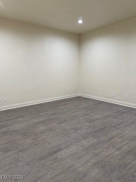 unfurnished room with dark hardwood / wood-style flooring