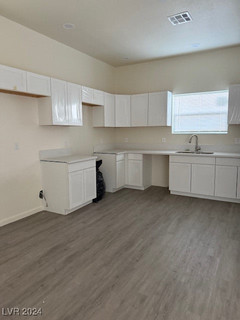 kitchen with hardwood / wood-style floors, sink, and white cabinets