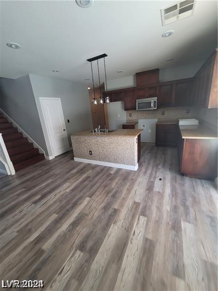 kitchen featuring sink, a kitchen island, pendant lighting, and dark hardwood / wood-style floors