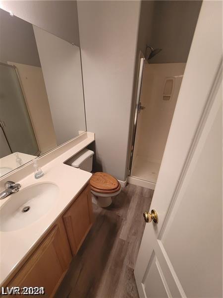 bathroom featuring a shower, toilet, vanity, and hardwood / wood-style flooring