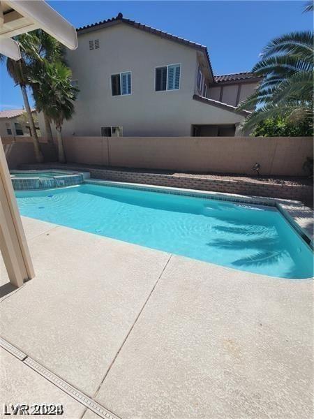 view of pool featuring a patio area and an in ground hot tub